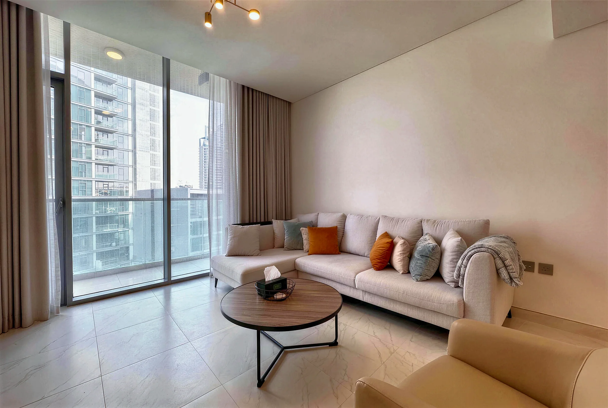 Living room with lagoon-side views, The Residences at District One